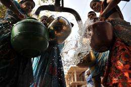 Indian women fill containers with potable water from a government water supply tanker
