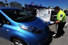 John Nielsen of the American Automobile Association (AAA) demonstrates charging a Nissan Leaf electric car