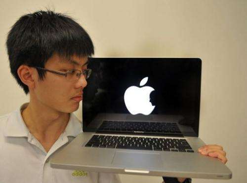 Jonathan Mak, a Hong Kong student poses with his laptop showing his logo in tribute of Apple founder Steve Jobs