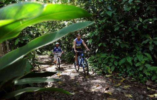 Joseph Mercadillio cycles with his son Jose Isaiah Mercadillio in a forest reserve in Manila on Environment Day