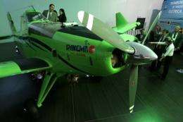 Participants look at a 100% ethanol powered aircraft made by Brazilian jet manufacturer Embraer
