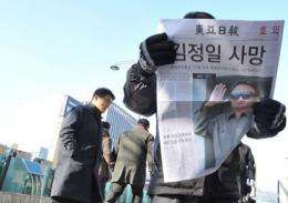 Pedestrians read a special edition a South Korean newspaper announcing the death of North Korean leader Kim Jong-Il