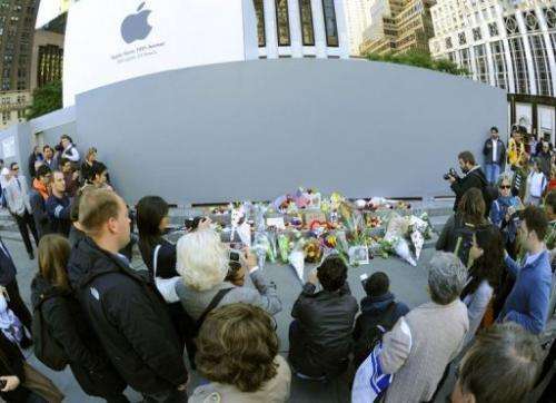 People gather around a makeshift memorial outside the Apple Flagship store
