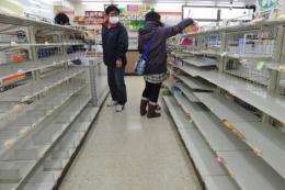 People look for food amid empty shelves in a shop in Fukushima