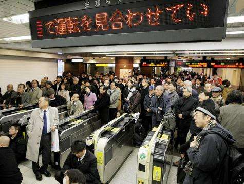 People wait for transport services to resume at the Tokyo station
