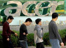 People walk past a logo of Acer in Shichih, Taipei