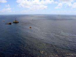 Supply boats cleaning an oil spill around a Chevron platform operating in the Frade oil field