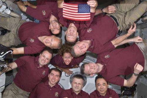 The Expedition 28 crew and the STS-135 Atlantis astronauts in a microgravity circle