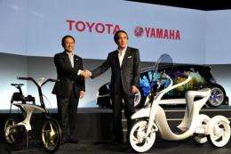 Toyota Motor and Yamaha Motor presidents display the electric commuter (R) and electric power assisted bicycle