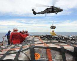 US sailors aboard the USS Blue Ridge move pallets of humanitarian relief supplies bound for Japan across the flight deck