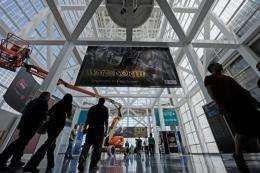 Workers hang banners in preparation for the E3 Expo