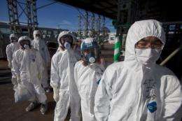 Workers in protective suits outside the emergency operation center at the Fukushima Daiichi nuclear power station