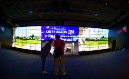 Workers put up a 3D videowall in the electronics giant LG's booth at the 51th edition of the IFA trade fair in Berlin