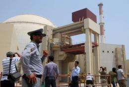 An Iranian security man stands next to journalists outside the Russian-built Bushehr nuclear power plant