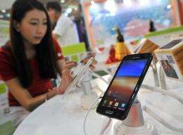 A South Korean woman inspects Samsung's smartphone "Galaxy Note" during an IT show in Seoul