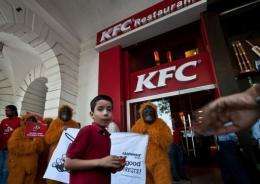 Greenpeace activists dressed as orangutans during a protest outside a KFC outlet in New Delhi on May 24