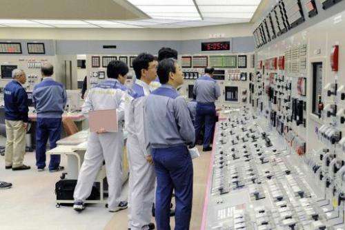 Kansai Electric Power Co (KEPCO) engineers check readings at the company's Oi nuclear power plant