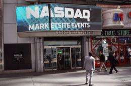 Pedestrians walk past the Nasdaq stock market at Times Square in New York City in March