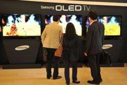 Visitors look at Samsung Electronics' new TVs that uses organic light-emitting diode (OLED) technology
