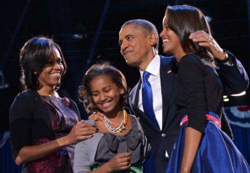 US President Barack Obama accompanied by First Lady Michelle and their daughters appears on stage on election night
