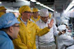 Apple chief executive Tim Cook (C-L) visits the iPhone production line at the newly built Foxconn manufacturing facility