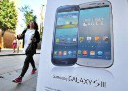 A woman walks past an advertisement for the Samsung Galaxy S3 at a mobile phone shop in Seoul on August 27, 2012