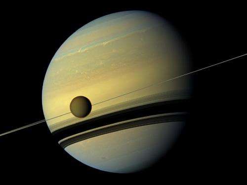 Saturn and its largest moon reflect their true colors