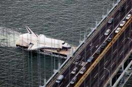 Space Shuttle Enterprise is carried by barge underneath the Verrazano-Narrows Bridge in New York City on June 3