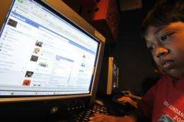 Abdu Rauf, a 12 year old Indonesian Facebook user, logs on at an Internet shop in Jakarta