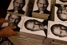 A bookshop employee piles up copies of a biography of the late "Apple" co-founder Steve Jobs in 2011