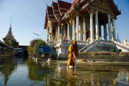 A Buddhist monk cleaning up an area at a temple inundated by flood waters in Don Muang district, in Bangkok, in 2011