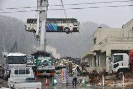A bus was removed from the roof of a building in Ishinomaki on the day after the March 11 earthquake-tsunami disaster
