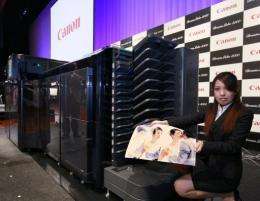A Canon representative displays a high-speed inkjet printer at the company's Tokyo HQ in February 2011