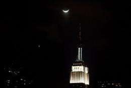 A crecent moon and Venus (L, point of light) set over the Empire State Building