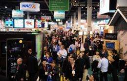 A crowd make its way between display booths along the aisles at the International Consumer Electronics Show in Las Vegas