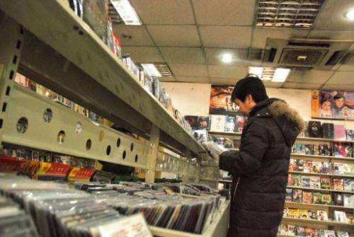 A customer is seen selecting pirated DVDs at a shop in Beijing, on January 2, 2010