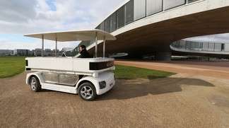 A driverless electric shuttle makes its way through the EPFL campus