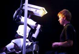A man adjusts a pole dancing robot on the Tobit Software stand at the CeBIT IT fair