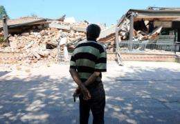 A man looks at damage after an earthquake in Cavezzo