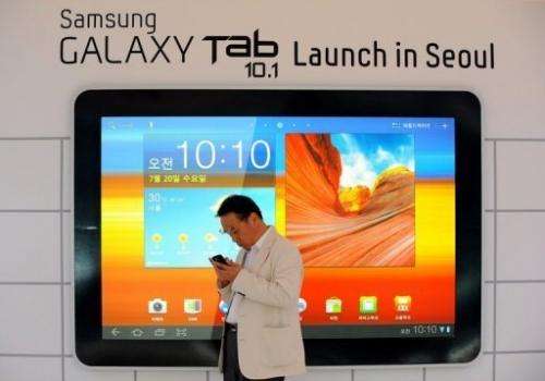 A man stands in front of an advert for Samsung Electronics' new tablet computer in Seoul in 2011