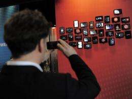 A man takes pictures with his mobile phone at the Mobile World Congress in Barcelona