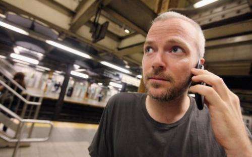 A man uses his cell phone in a subway station in New York