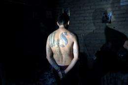 An alleged gang member is handcuffed in Mejicanos, a suburb of San Salvador
