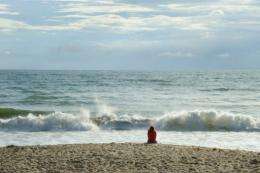 An early morning beach goer looks out over the Atlantic Ocean in Florida