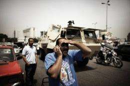 An Egyptian man talks on the telephone in front of an army vehicle in central Cairo's Tahrir Square in May 2012