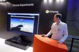 An employee stands next to a giant screen for "Chrome Experiments"