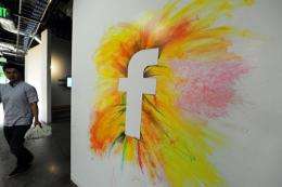 An employee walks past one of the many wall graffitis at the Facebook headquarters in Menlo Park, California