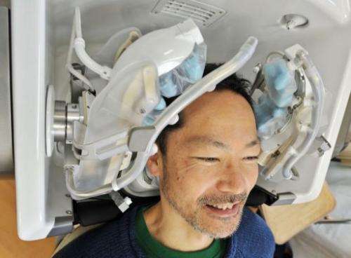 A prototype of a high-tech head massager is tested out by a Japanese tsunami survivor