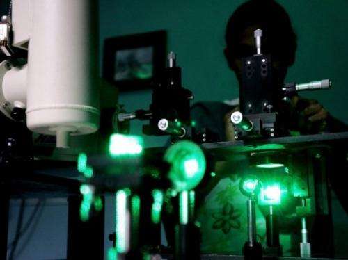 A research scholar experiments with laser rays in a lab
