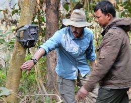 A scientist sets a motion-activated camera  in a national park in Nepal